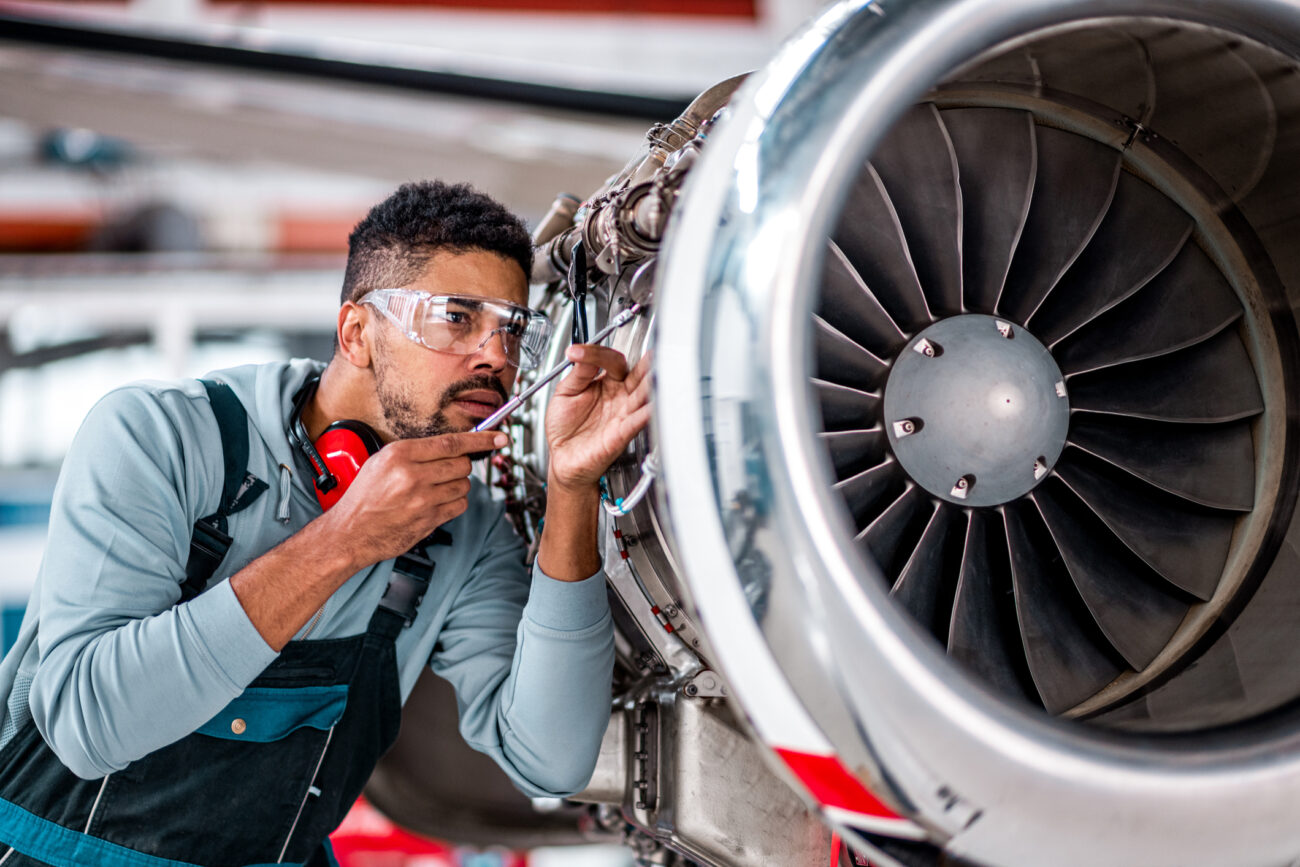 young male engineer checking the airplane jet