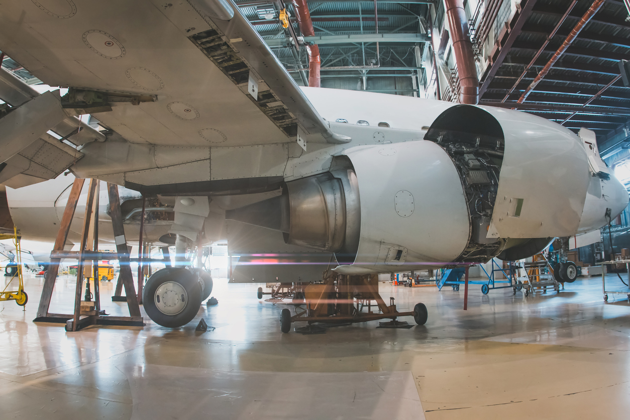 close up of a white passenger jet plane with its engine open in the aircraft hangar. airliner under maintenance
